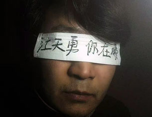 A Chinese supporter of detained human rights lawyer Jiang Tianyong wears a blindfold saying, "Jiang Tianyong, where are you?" in an undated photo.
