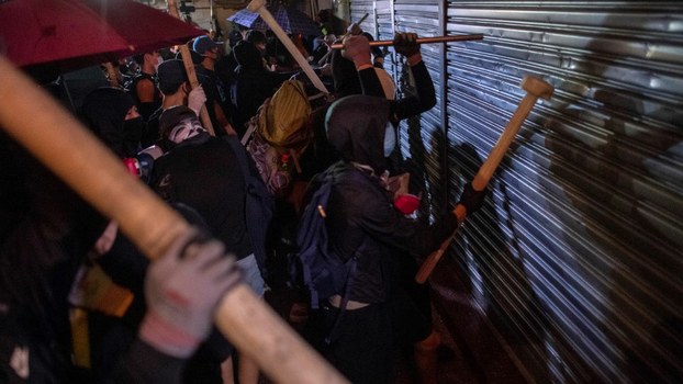 Protesters try to break into shops in the Tsuen Wan district, in Hong Kong, Oct. 2, 2019.