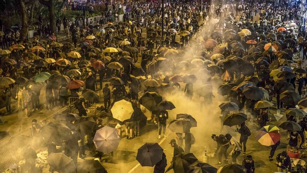 Protesters react as police fire tear gas while they attempt to march towards Hong Kong Polytechnic University in Hung Hom district of Hong Kong on November 18, 2019.