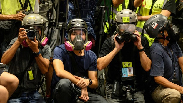 Journalists wear protective gear and high visibility vests during a press conference to highlight allegations that police have mistreated and obstructed the media when covering clashes between the police and protesters, at police headquarters in Hong Kong on Sept. 9, 2019.