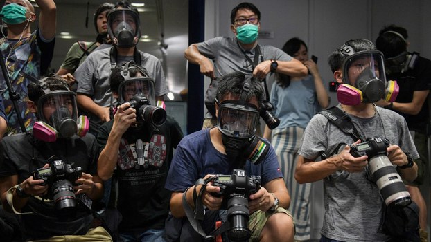 Photojournalists wearing protective masks attend a police press conference in Hong Kong Oct. 8, 2019. 