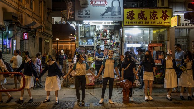 Masked students and protesters gather to form a human chain along a street in Hong Kong, Oct. 18, 2019.