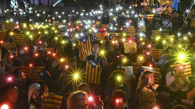 People hold Catalan pro-independence "Estelada" flags and light up their mobile phones during a Hong Kong-Catalonia solidarity assembly in Central district in Hong Kong, Oct. 24, 2019.