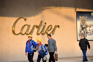 Pedestrians walk past a Cartier store in Beijing, Nov. 18, 2011.