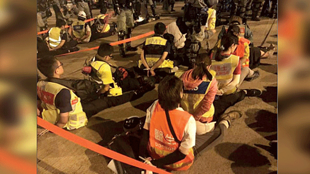 Medical team workers are shown detained by riot police outside Hong Kong's Polytechnic University, Nov. 17, 2019.