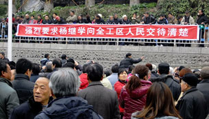 Retired workers from the Gezhouba Group hold banners protesting inadequate stipends in Yichang, Feb. 22, 2012.