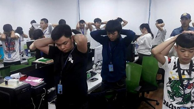 n this handout photo provided by the Philippine Bureau of Immigration, foreign nationals, mostly Chinese, put their hands on their heads during a raid of their company premises in Manila, Oct. 10, 2019. 