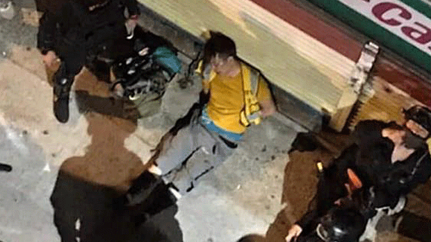 A Hong Kong protester lies injured on the ground after being assaulted by police, Sept. 21, 2019.