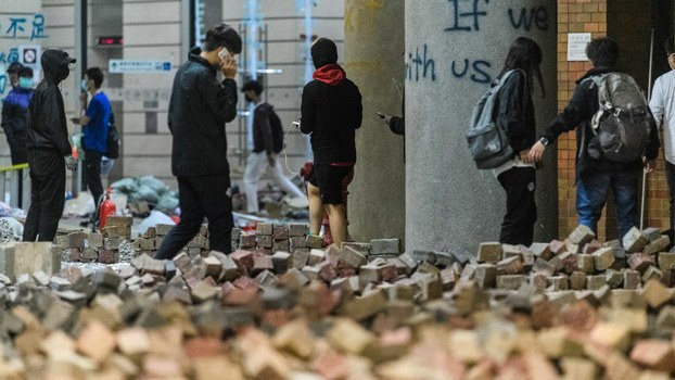 Anti-government protesters walk towards a makeshift area to prepare for being taken by paramedics to ambulances from the campus of the Hong Kong Polytechnic University (PolyU) after being barricaded inside for days, Nov. 20, 2019.