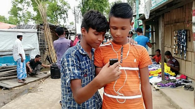 Rohingya teens use a cellphone to access the internet at a refugee camp in Bangladesh’s Cox’s Bazar district, Aug. 3, 2019.