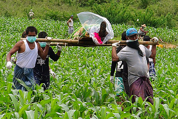 Villagers carry the corpse of a civilian found in a shallow grave in Mong Yaw subtownship, Myanmar's northern Shan state, June 30, 2016.