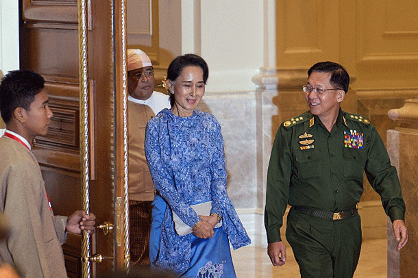 Myanmar's Aung San Suu Kyi (C) and military chief Senior General Min Aung Hlaing (R) arrive for the handover-of-power ceremony at the presidential palace in Naypyidaw, March 30, 2016.