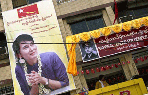 An activist looks out of a newly opened NLD office with a portrait of Ang San Suu Kyi in downtown Rangoon, Feb. 27, 2012.