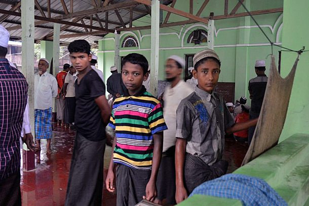 Rohingya Muslim men and boys arrive for Friday prayers at a camp in Sittwe, western Myanmar's Rakhine state, June 10, 2016.  